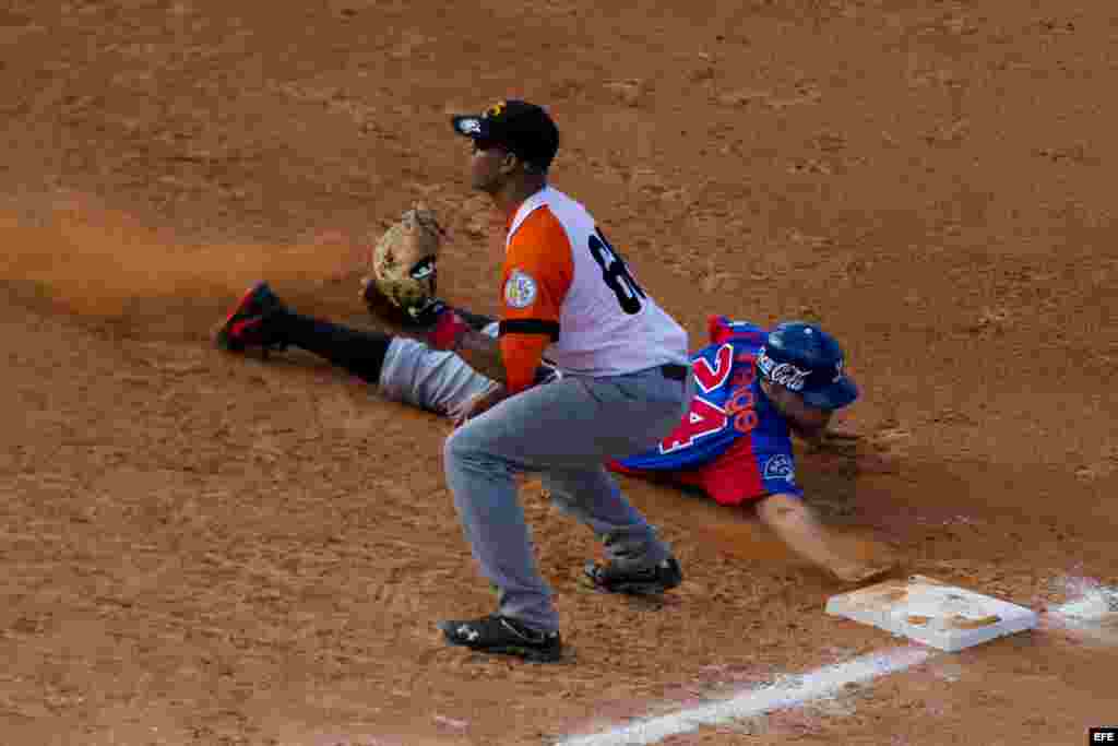 Ramon Lunar (i), de Villa Clara de Cuba, intercepta una pelota en primera base ante Juan Perez (d) de Tigres del Licey de República Dominicana hoy, lunes 3 de febrero de 2014, durante el tercer día de la Serie del Caribe 2014, en el Estadio Nueva Esparta, en Margarita (Venezuela). 